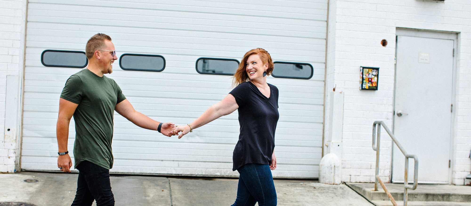 Shelly and Jason walking hand in hand along a city street, laughing